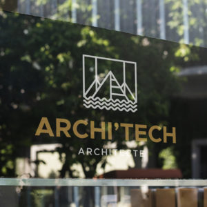 Logo Architecte blanc sur une vitrine en verre