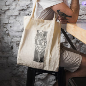 Sac beige avec le logo d'un verre a cocktail et une vague au dessus